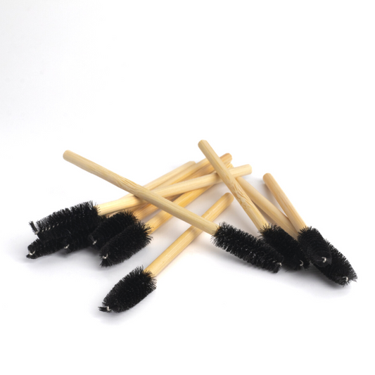 A pile of bamboo eco-friendly mascara wand brush with black handle